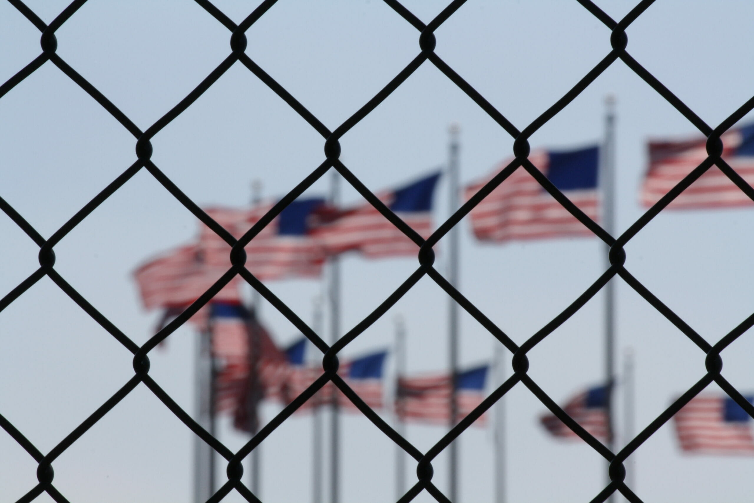 American flags behind a border fence