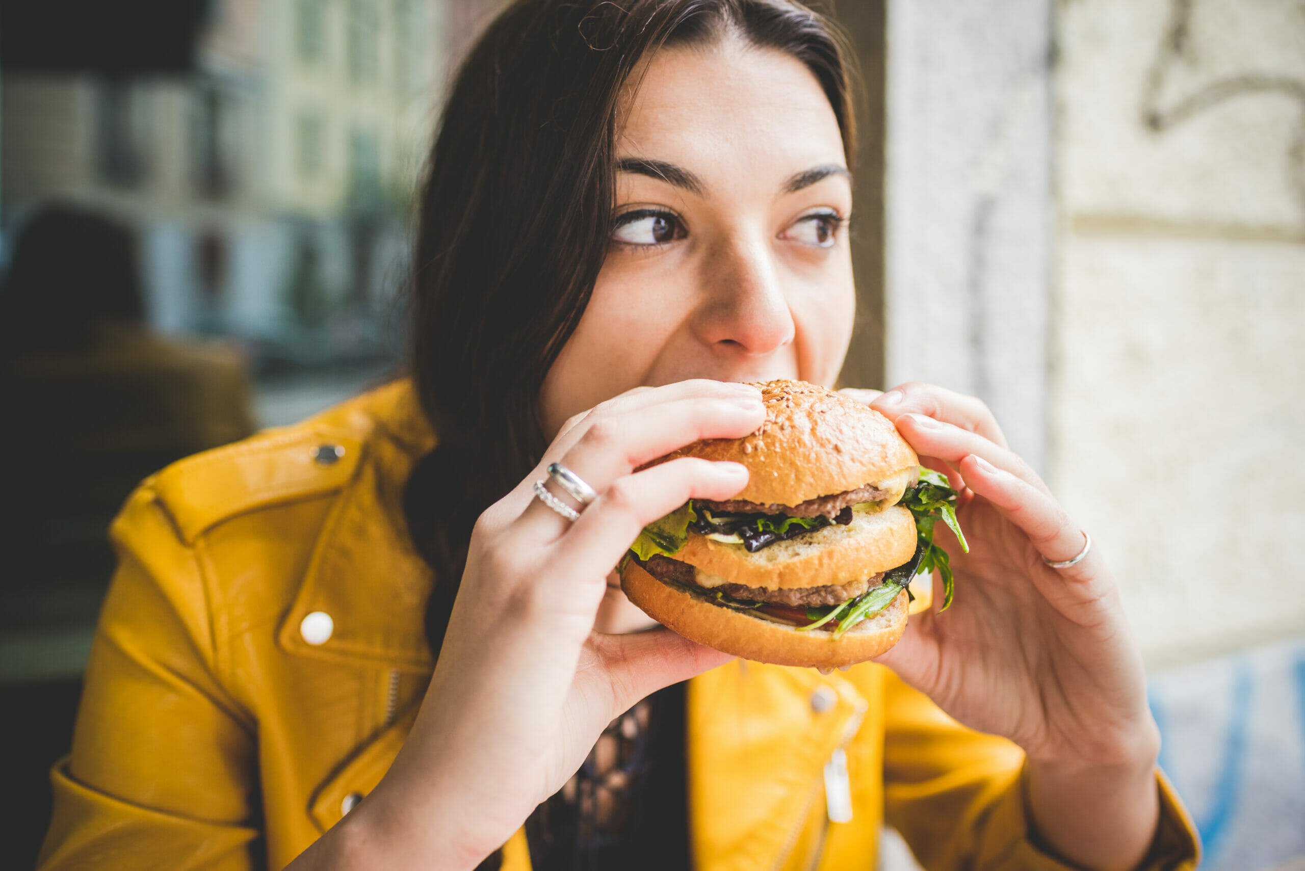 An immigrant woman eating a burger