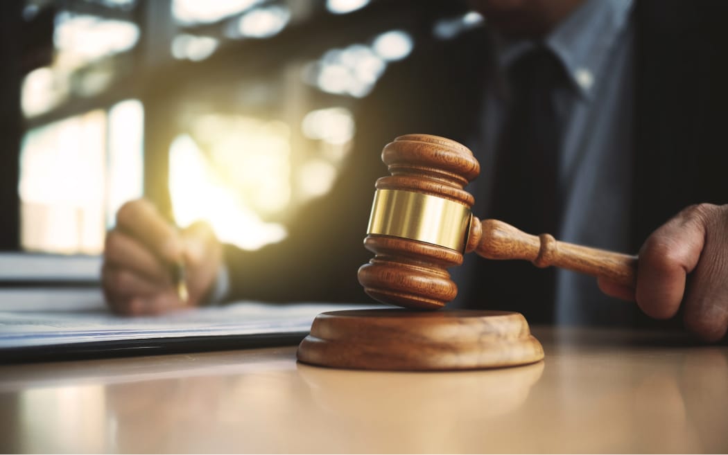 A wooden gavel rests on a judge's bench in a federal courtroom, symbolizing the court's power to decide the fate of the Keeping Families Together immigration program