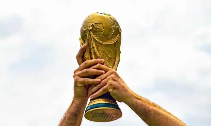 person holding up 2026 fifa world cup trophy
